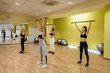 © Andrii - A group of young athletic girls perform exercises in the gym under the guidance of a coach. Healthy lifestyle