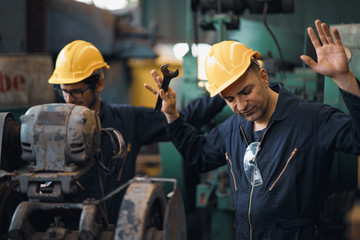 Shot of two industrial workers feeling bad with old system in the factory, the worker feels upset and show give up, Concept industrial workers with bad emotion when working time, working confliction.