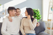 © Studio Romantic - Happy family at home. Mother father and daughter sitting on sofa in room.