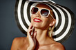 Beautiful smiling woman in hat and sunglasses - close up portrait