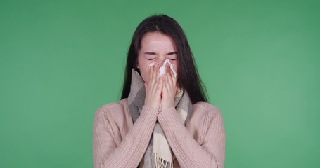 Canvas Print - Young woman suffering from cold on green background