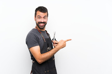 Barber man in an apron pointing finger to the side