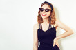 © MoreThanProd - Hipster girl whole in a black dress, on a white background. Girl in unusual sunglasses and earrings. Fashion girl with a short haircut. Place for text