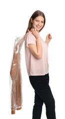 Poster - Young woman holding hanger with dress in plastic bag on white background. Dry-cleaning service