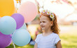© Halfpoint - Small girl standing outdoors in garden, birthday celebration concept.