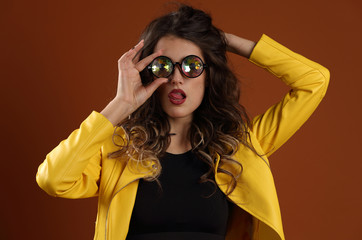 Beautiful girl in a yellow jacket and kaleidoscope glasses