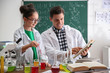 © New Africa - Teacher with pupil making experiment at table in chemistry class