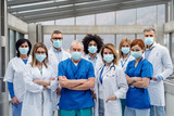 Fototapeta  - Group of doctors with face masks looking at camera, corona virus concept.