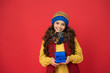 © be free - Holidays season. Happy childhood. Christmas gifts and souvenirs. Winter holidays. Happy kid in winter outfit red background. Pick some winter gifts for yourself. Wish list. Consume consciously
