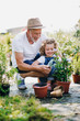 © Halfpoint - Small girl with senior grandfather in the backyard garden, gardening.