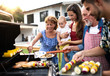 © Halfpoint - Portrait of multigeneration family outdoors on garden barbecue, grilling.