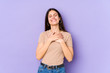 © Asier - Young caucasian woman isolated on purple background laughing keeping hands on heart, concept of happiness.