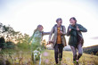 © Halfpoint - Senior women friends with dog on walk outdoors in nature.