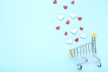 Wall Mural - Colorful hearts with shopping cart on blue background