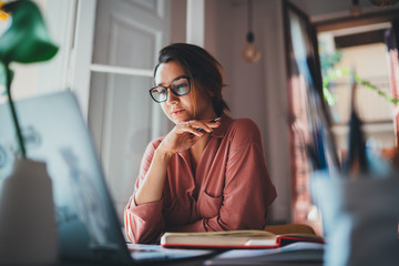Beautiful businesswoman sitting at table opposite laptop in workplace brainstorming new project, People technology Concept