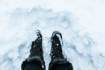 Woman legs with Winter boots in the snow