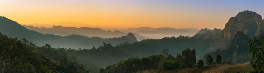 Wall Mural - Beautiful sunrise in mountains with white fog below panorama