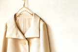 Fototapeta Sypialnia - 白バックに白のジャケットの肩や襟のクローズアップ