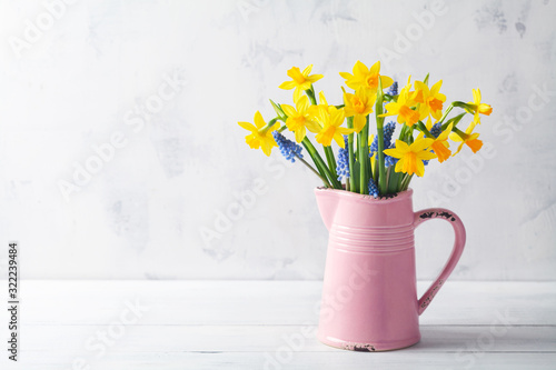 Beautiful spring composition with daffodil flowers in vase on white background Poster Mural XXL
