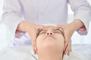 Therapist doing Tui na massage at her patient face ,Chinese alternative medicine.