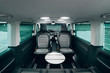Interior of luxury van with comfortable leather seats and table. Expensive interior of modern transfer car. Cozy and bright transfer shuttle car for business trip