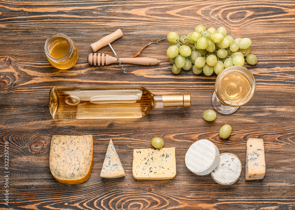 Delicious wine with cheese and honey on wooden background