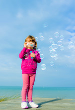 Beautiful Little Girl Blowing Soap Bubbles