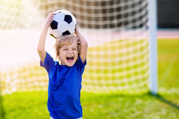 Kids play football. Child at soccer field.