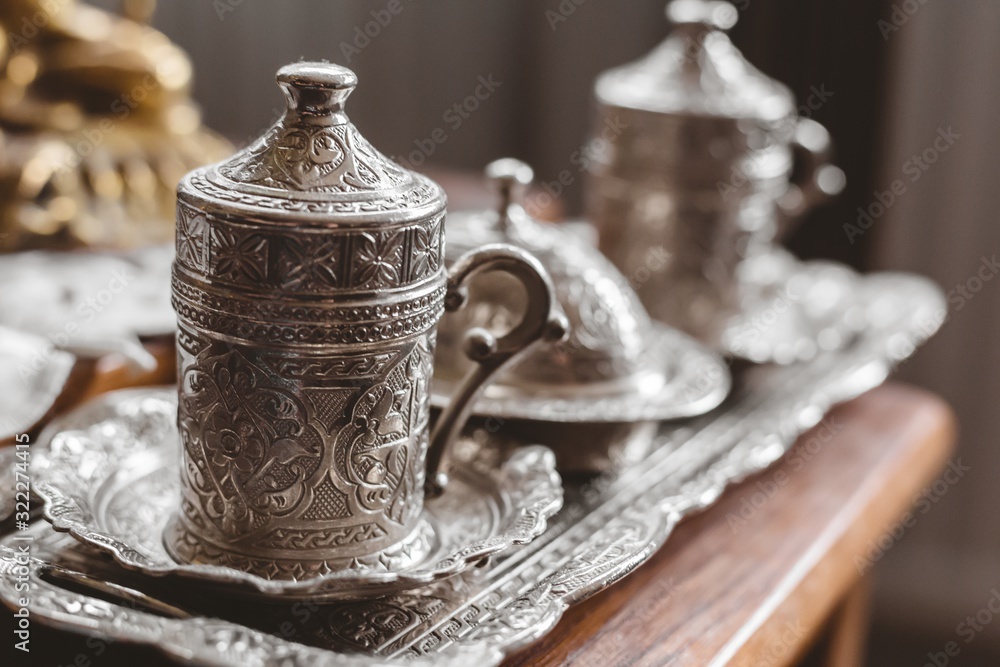Closeup shot of an antique silver tea set with a blurry background - obrazy, fototapety, plakaty 