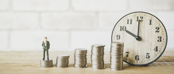 Wall Mural - miniature business man with blurred coins and calendar , business and finance concept