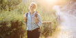 © Dan Race - Woman with backpack hiking through forest and nature on a sunny summer day