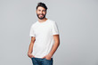 © baranq - Handsome young man smiling isolated on grey background wearing casual t-shirt and jeans