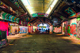 Fototapeta Młodzieżowe - London, UK/Europe; 21/12/2019: Leake Street, underground tunnel with graffiti covered walls in London. Scene with pedestrians and graffiti artists.