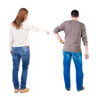 © ghoststone - Back view of couple couple in sweater pointing.