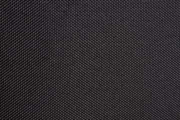 Black dense fabric, background. Close-up.