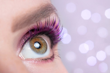 Beautiful fashionable eye makeup close-up, macro on a blurry pink background with bokeh