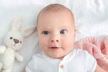 Portrait of cute little baby lying on bed