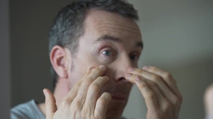 Wall Mural - Portrait of man applying cosmetics on his face