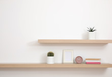 Wooden Shelves With Books And Decorative Elements On Light Wall