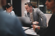© Flamingo Images - Mature businessman smiling during a staff meeting in an office