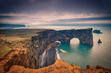 Fototapeta Morze - Famous tourist landscape with basalt rocky cape and ocean. Southern coast of Iceland. Black sand Beach View of peninsula Dyrholaey, Reynisdrangar, Vik, Iceland, Atlantic Ocean, Europe. Travel postcard