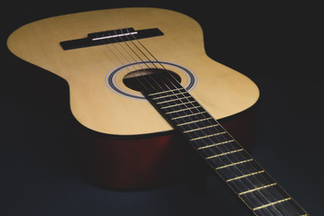 Acoustic guitar on the black background. musical instrument