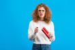 irritated woman in eyeglasses holding dynamite and lighter, isolated on blue