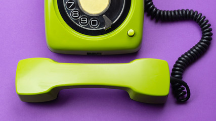 Classic phone with handset. vintage green telephone with phone receiver isolated on purple background. old communication technology