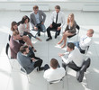 © ASDF - business training participants sitting in a circle and looking at the camera