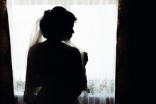 Silhouette Of The Bride Opposite The Window On A Black And White