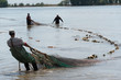 © stillkeeper - Fisherman drags and trawls the fishing net with fish in the river