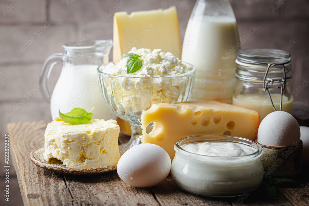 Fresh dairy products, milk, cottage cheese, eggs, yogurt, sour cream and butter on wooden table - obrazy, fototapety, plakaty 