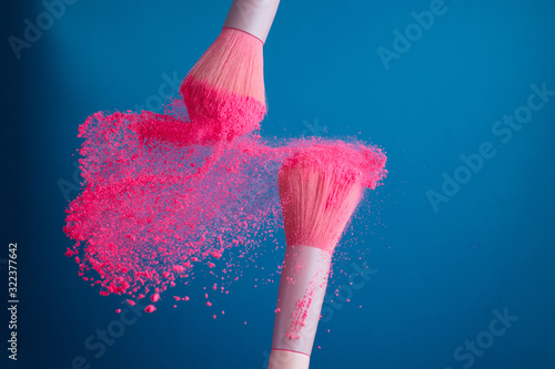 Fotografía close-up photo of two professional make-up brushes with pink powder in motion on