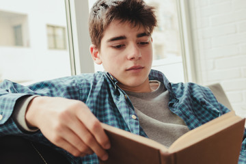 Wall Mural - young teenage boy reading or studying at home